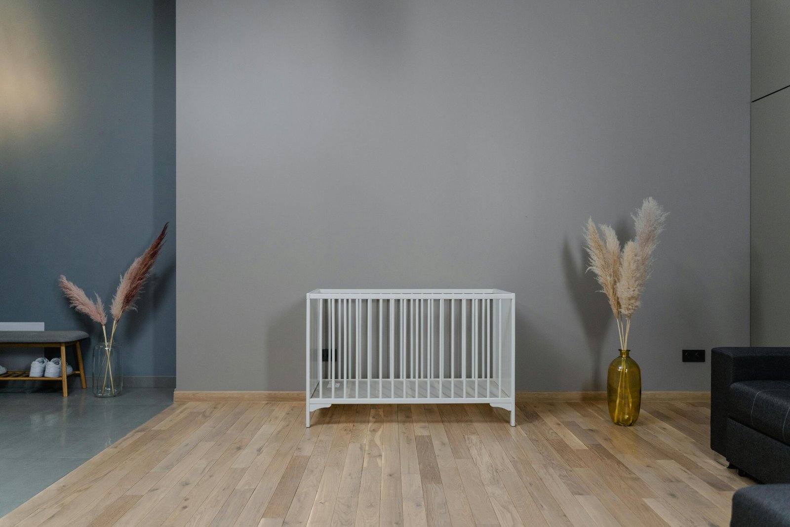 A modern minimalist nursery with a white crib and decor in earthy tones.